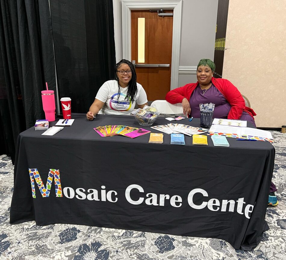 Two members of the Mosaic Care Center team tabling an event at Community Connections Expo hosted by FAHASS in Fredericksburg, VA.