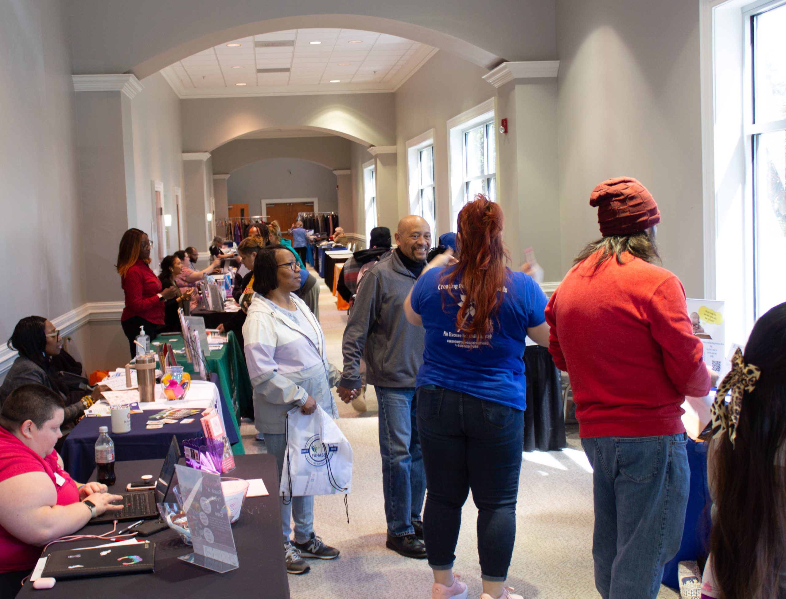 Attendees at a Community Connections Expo in Fredericksburg, VA browse booths offering free community resources.