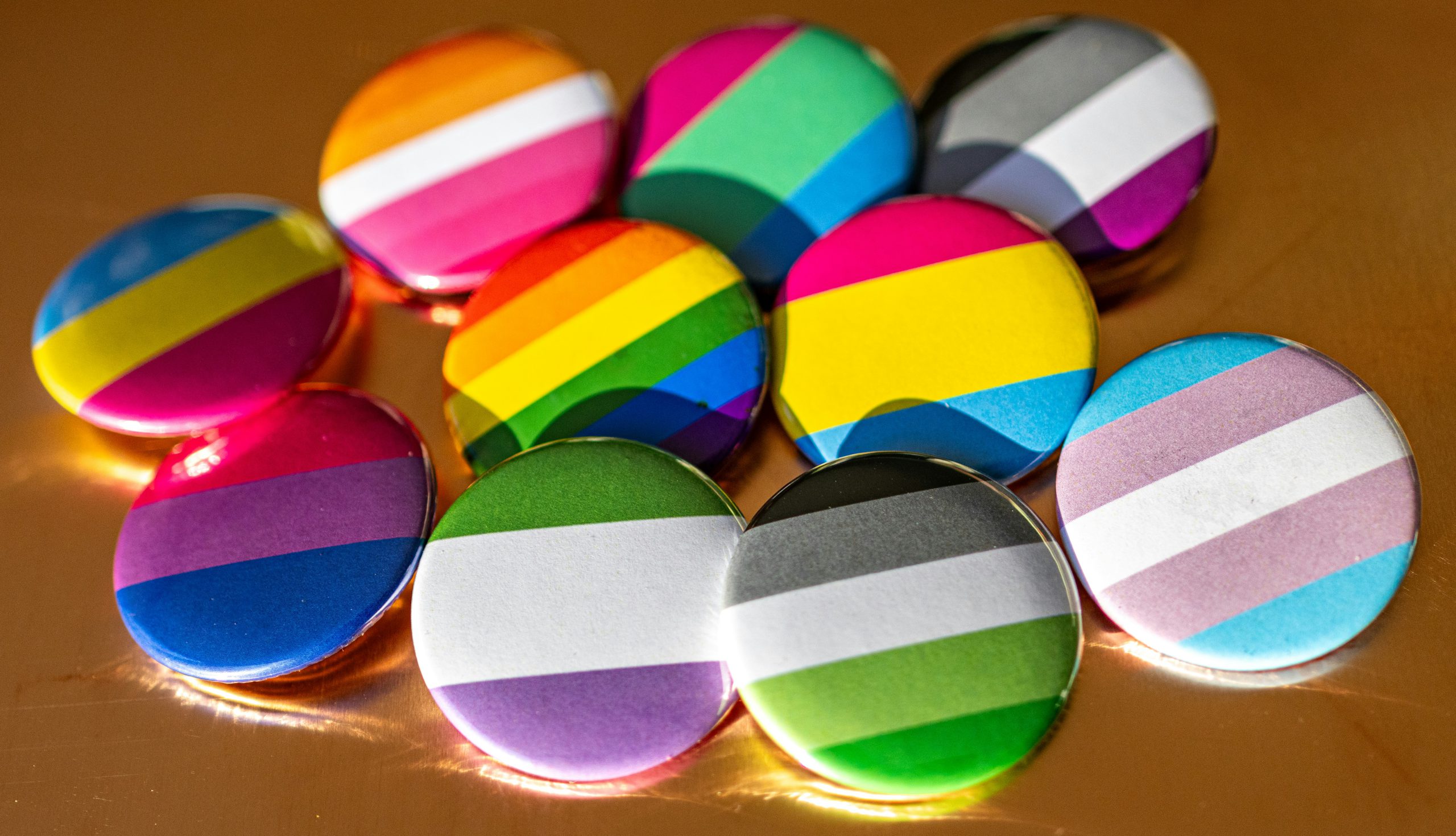 Colorful buttons featuring various LGBTQ pride flags, representing LGBTQ resources and community support offered by Pride Center FXBG.