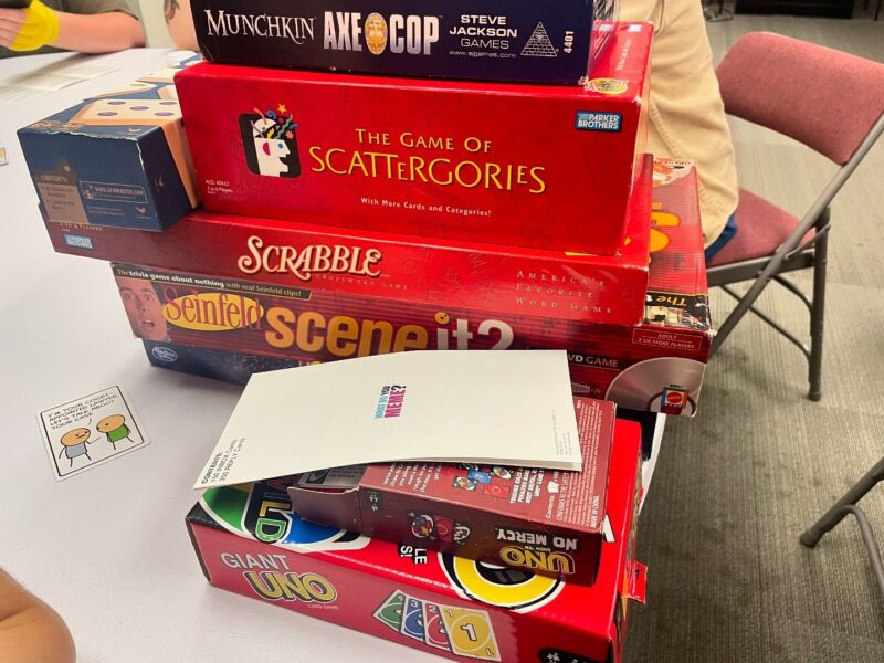 A stack of board games representing LGBTQ Board Game Night, hosted by Pride Center FXBG in Fredericksburg, VA.