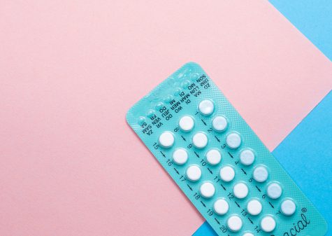 A pack of birth control pills on a pastel background, representing gender-affirming hormone therapy (HRT) available at Mosaic Care Center.
