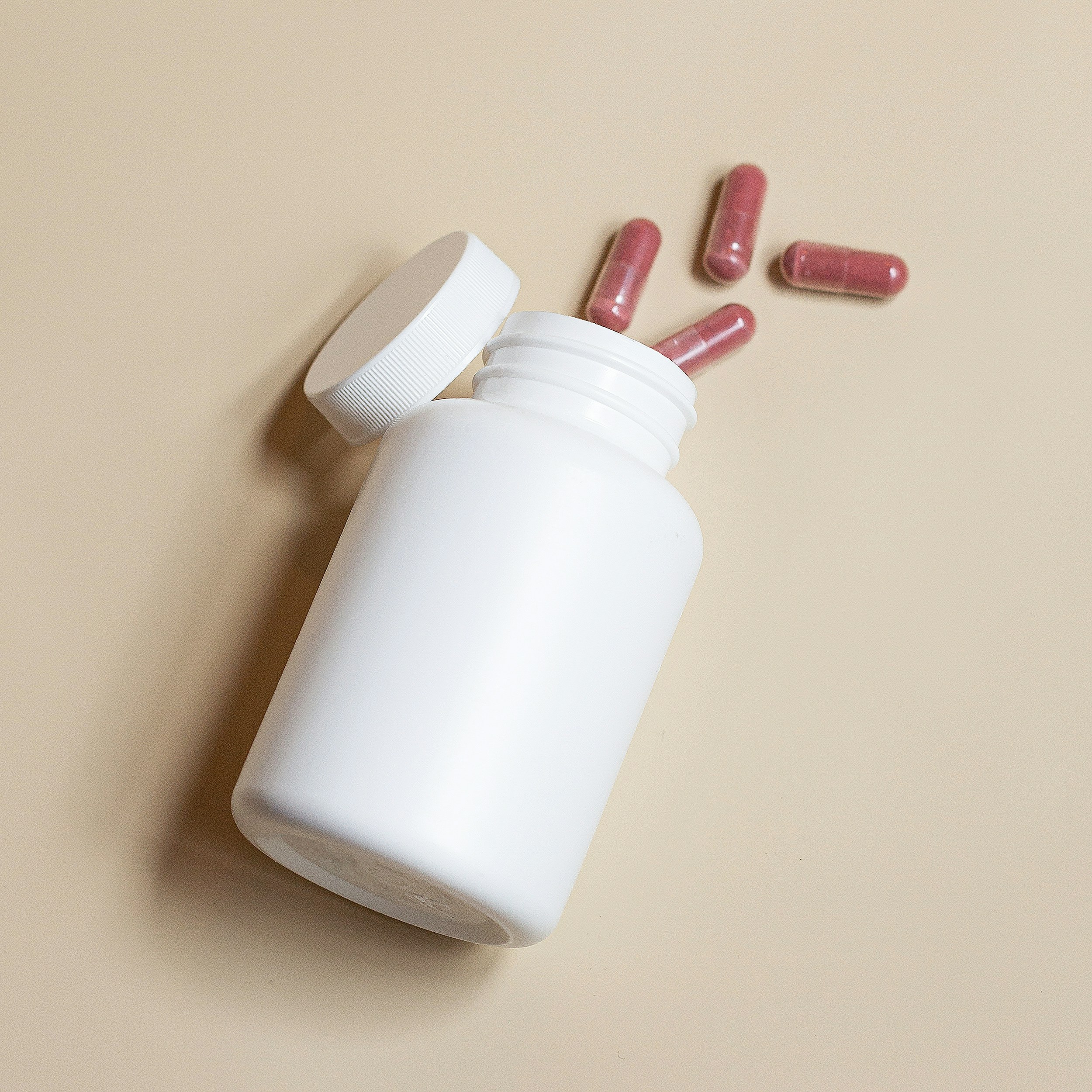 A white prescription bottle with pills spilling out, representing access to PEP and DoxPEP at Mosaic Care Center.