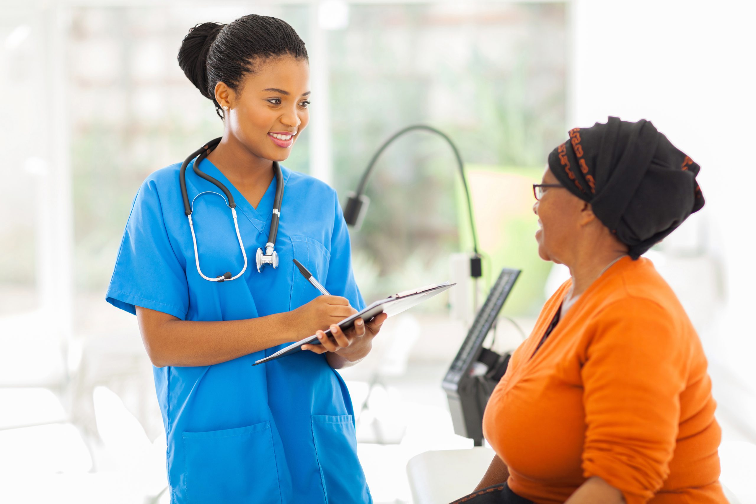 A young health professional taking medical history from a patient, representing personalized care in outpatient healthcare at Mosaic Care Center.