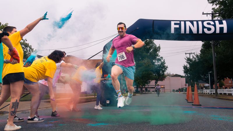 A runner finishing the 6th Annual Rainbow Run hosted by FAHASS in Fredericksburg, VA