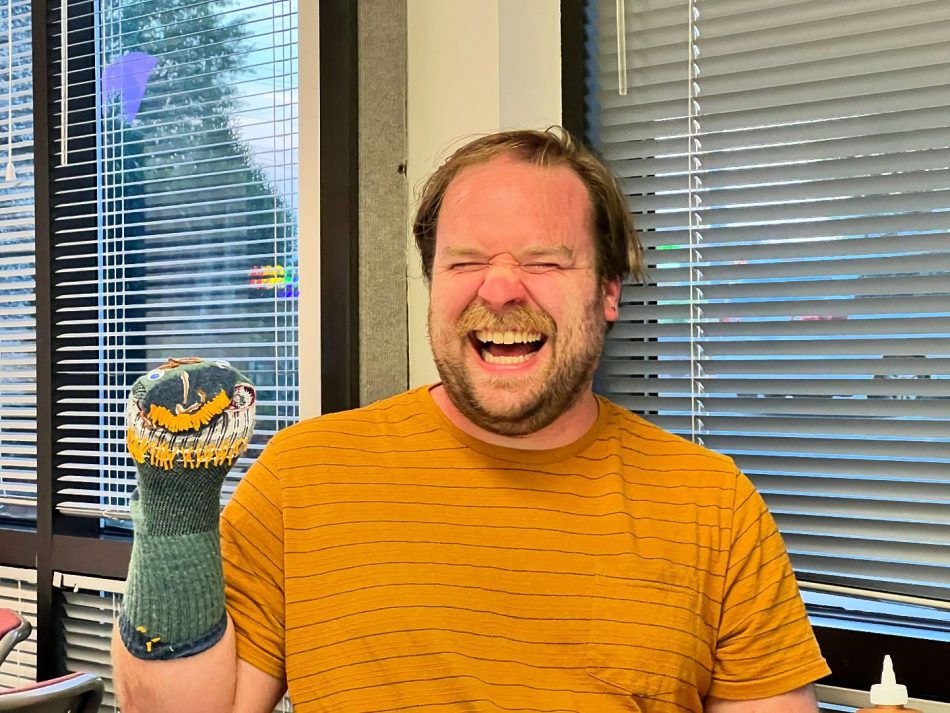 A happy person with a sock puppet at Pride Center FXBG's Queer Craft Night in Fredericksburg, VA