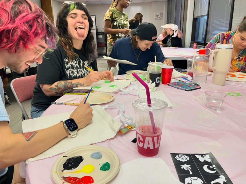 A group of diverse friends painting their own cavnas tote bags at Queer Craft Night hosted by Pride Center FXBG.