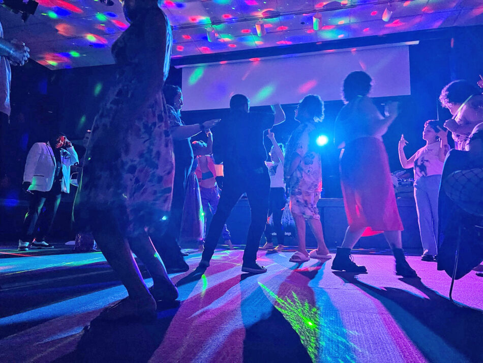 A dance floor with colorful lights and people dancing at Pride Prom hosted by FAHASS' Pride Center and Pride FXBG.