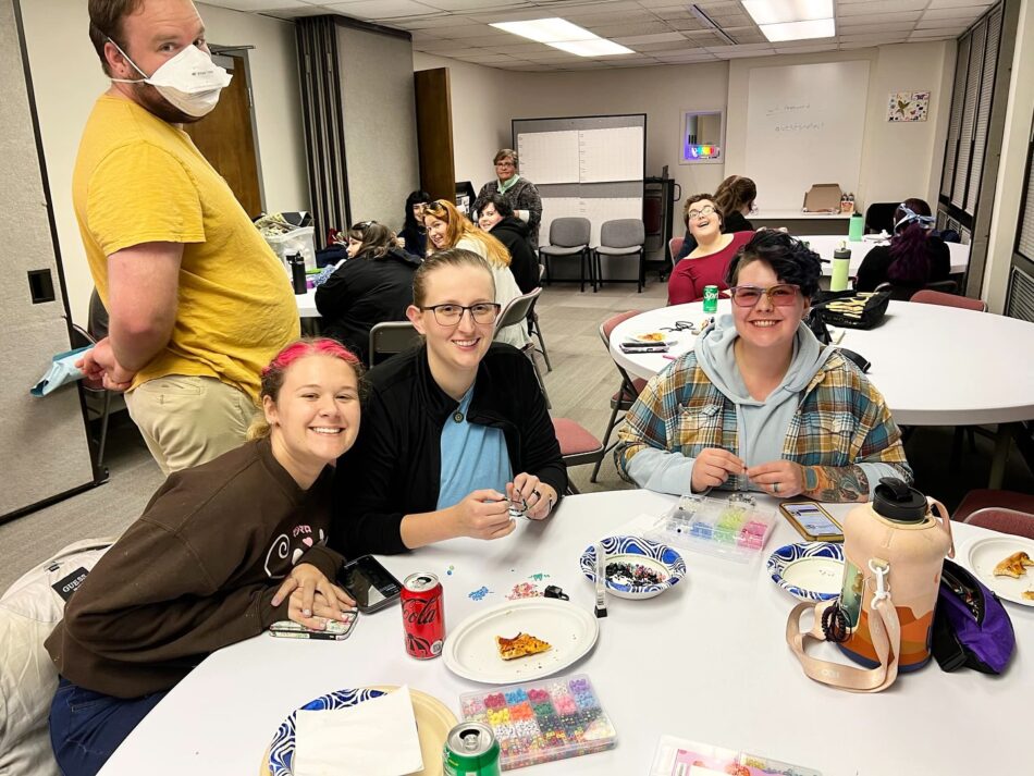 A group of diverse friends making bracelets at Queer Craft Night hosted by FAHASS, Pride Center FXBG, and the House FXBG.